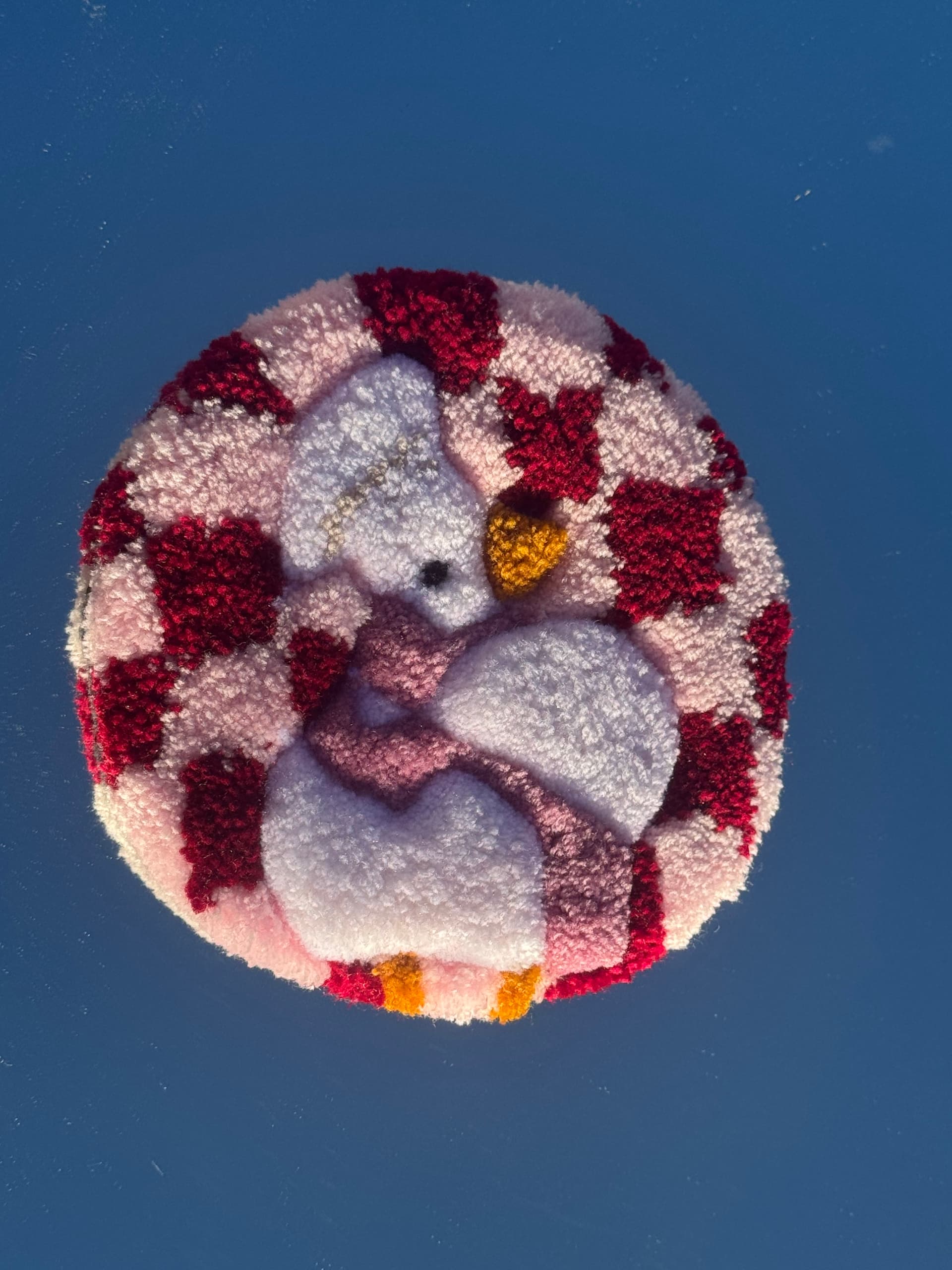A sweet handmade tufted coaster featuring an adorable white duck dressed with a soft pink bow, set against a burgundy and blush pink checkerboard background. π¦π Fluffy, playful, and full of personality